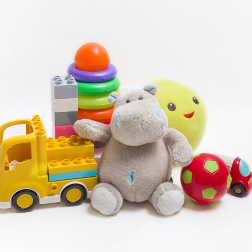 Group of childrens toys on a white background. Constructor, pyramid, ball and soft toys for children's development